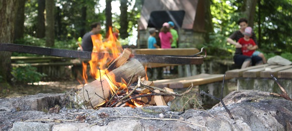 Familie an einer Grillstelle im Wald